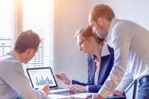 Accounting team discussing financial report data with chart on computer screen in office, consulting people reviewing corporate strategy and business analytics metrics